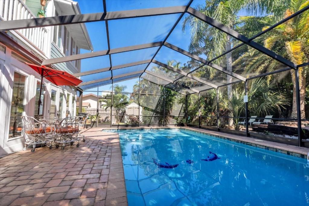 an indoor swimming pool with a glass ceiling at Sneaky Tiki: Heated Saltwater Pool+5 min to beach in Largo