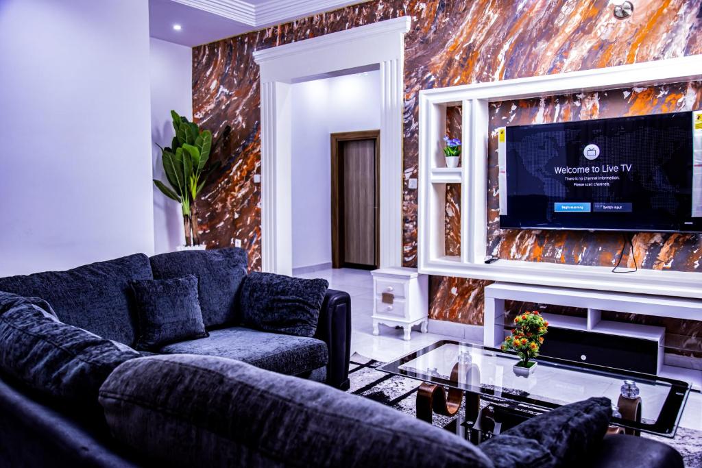 sala de estar con sofá y TV en PINORICH VILLA-Buea en Buea