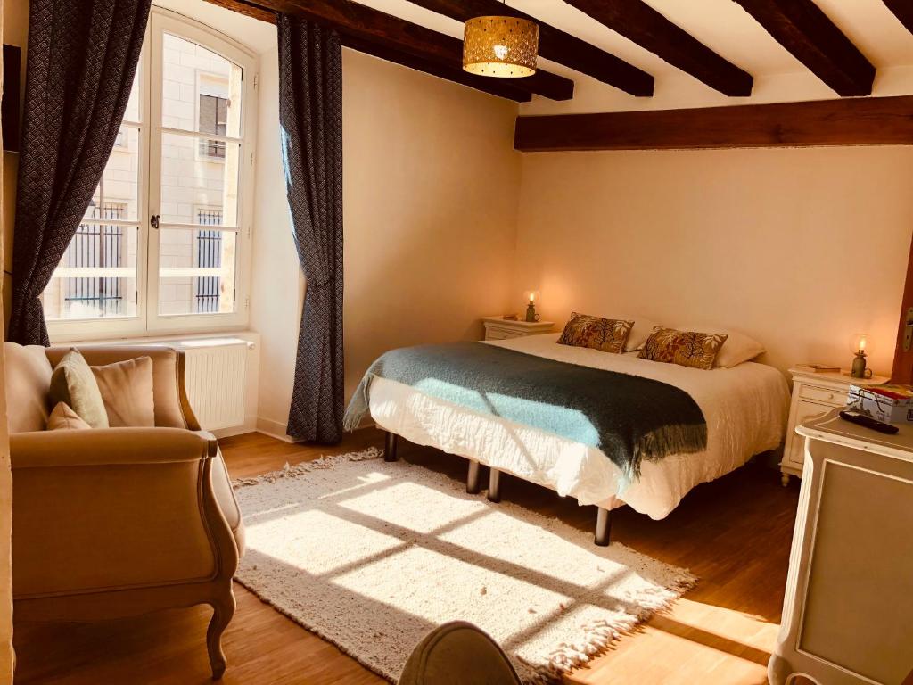 1 dormitorio con cama, sofá y ventana en L’AMANTINE Chambres d’hôtes et gîte, en Bourges