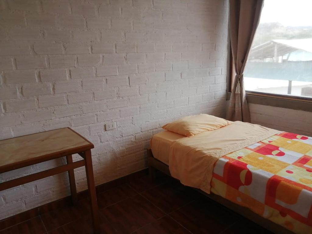 a small bedroom with a bed and a window at CASA VILLA SOL in Tumbes