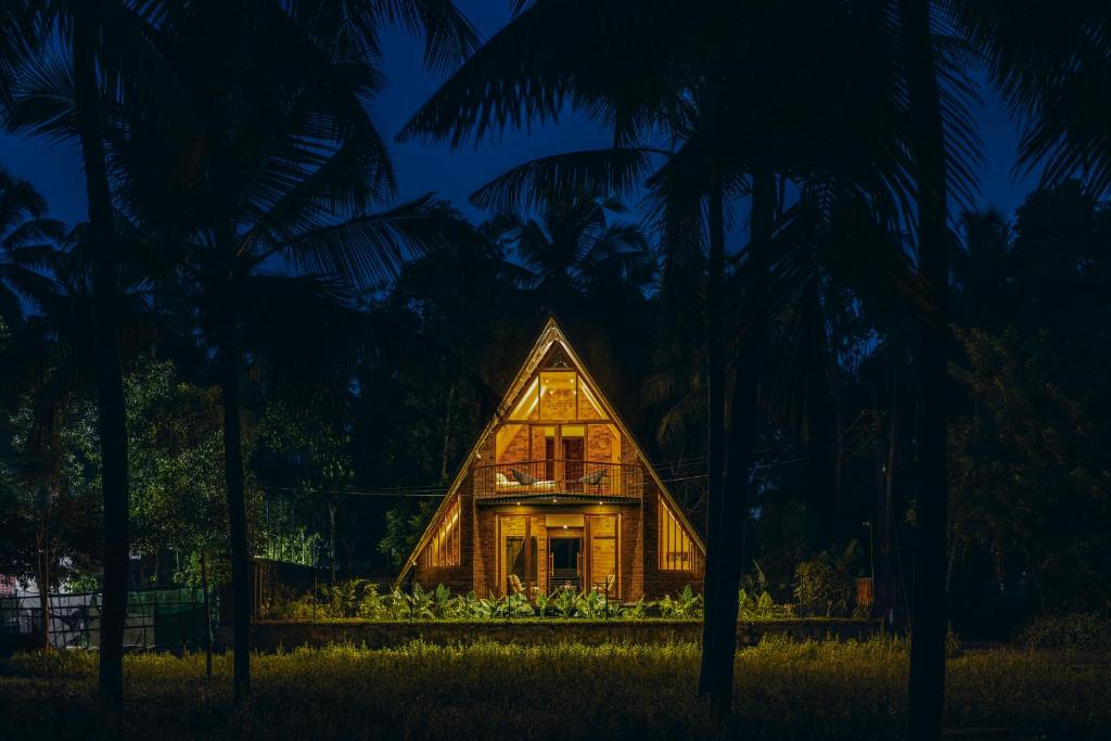 a house in the middle of a forest at night at Bimal's Casa de Papel in Kadikkād