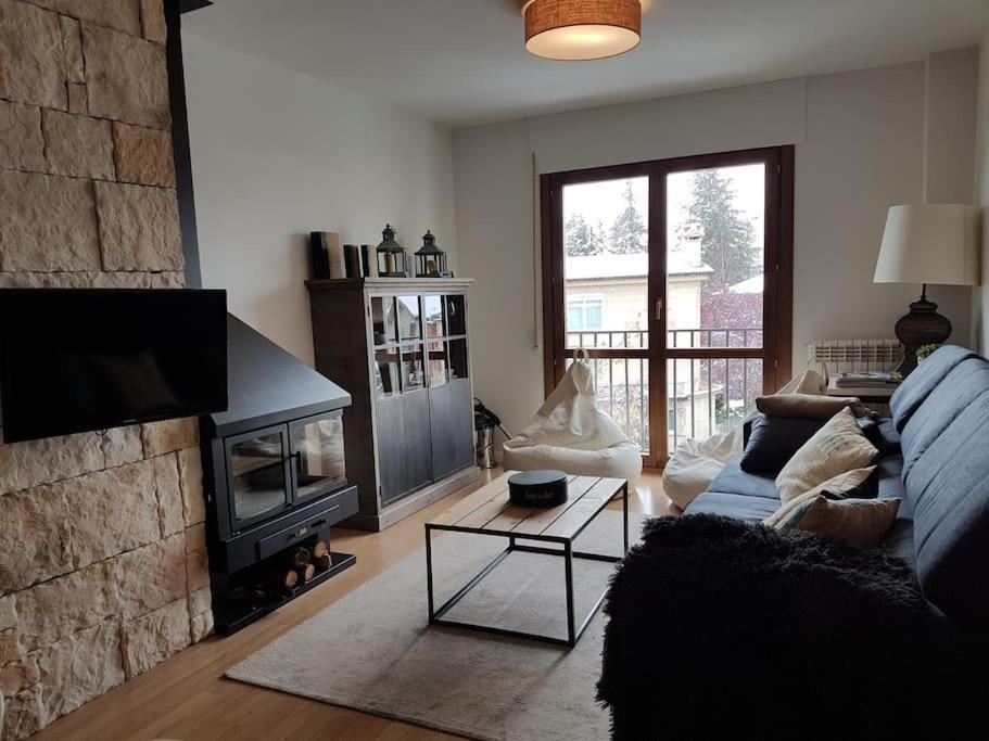 a living room with a couch and a fireplace at Vivienda reformada con GARAJE, PISCINA y WIFI in Jaca