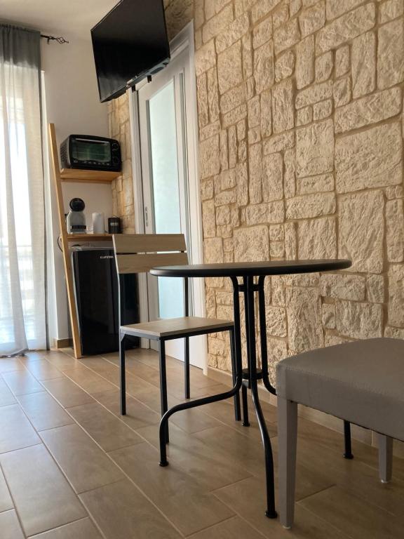tavolo e sedie in una stanza con parete in pietra di Wanderlust house a Bari