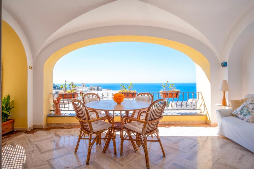 Un comedor con mesa y sillas y el océano. en Dimora Bruno e Rubina (centrale a Capri), en Capri