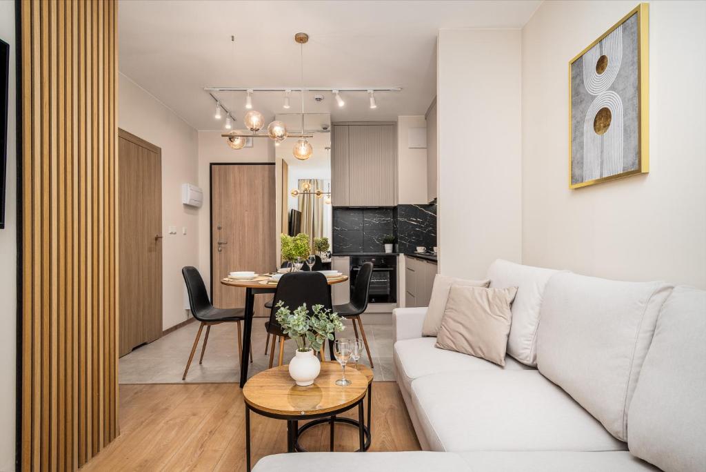 a living room with a white couch and a table at AYCON APARTMENTS - MODERN SPACE in Warsaw