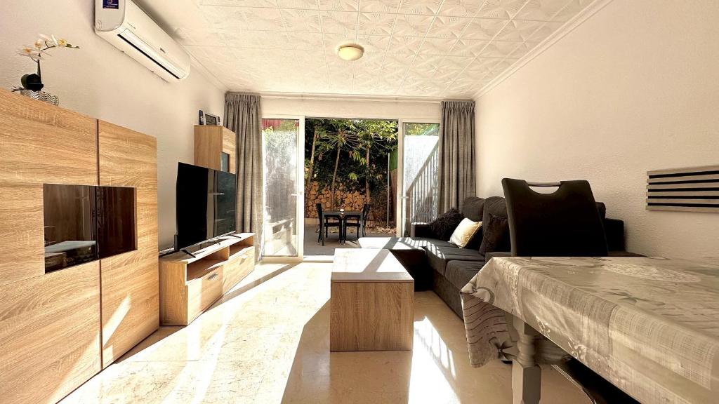 a living room with a couch and a television at Bungalow Playa Poniente Benidorm in Benidorm