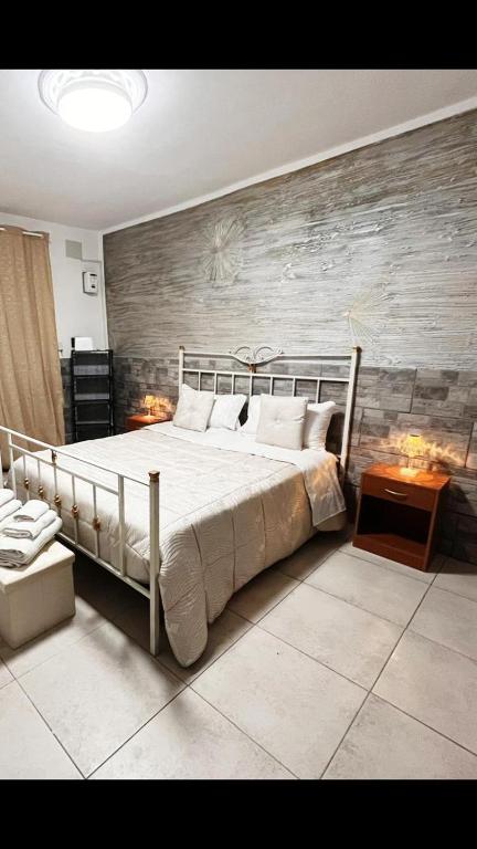 - une chambre avec un grand lit et un mur en bois dans l'établissement the cousins' house, à Palerme