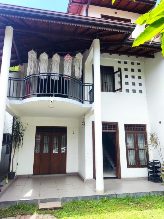 a white house with a balcony and two doors at Coco Bay in Beruwala