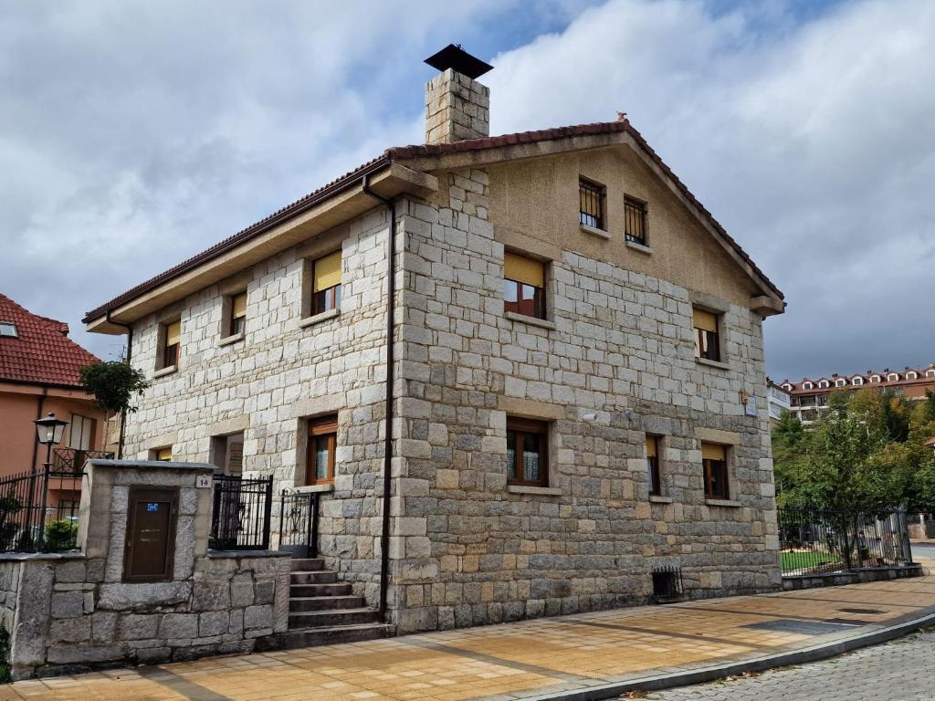 a stone building with a chimney on top of it at Los Kukos Casa Rural in Riaño