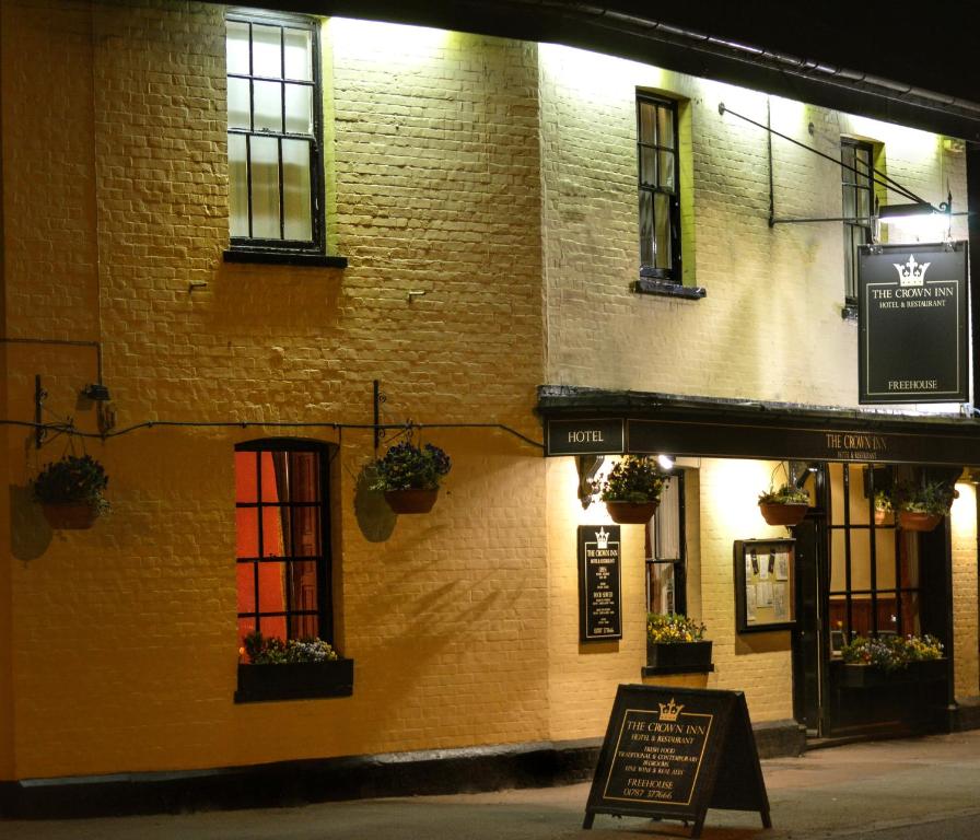 een gebouw met ramen en een bord ervoor bij The Crown Inn Hotel in Long Melford