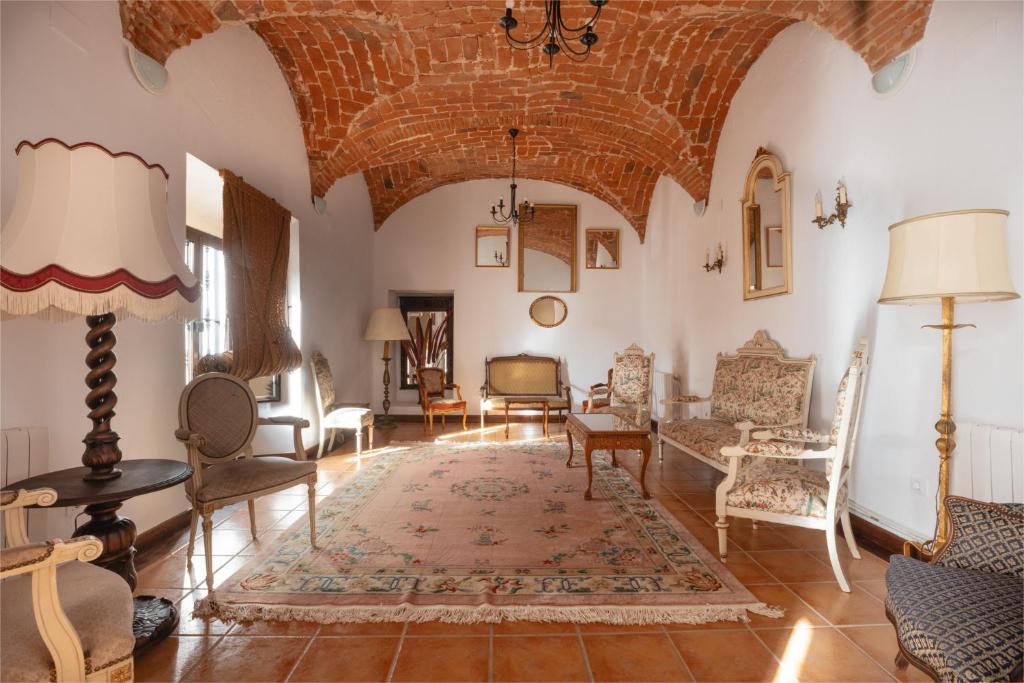 a living room with furniture and a large ceiling at Alojamiento El Monasterio in Almonaster la Real