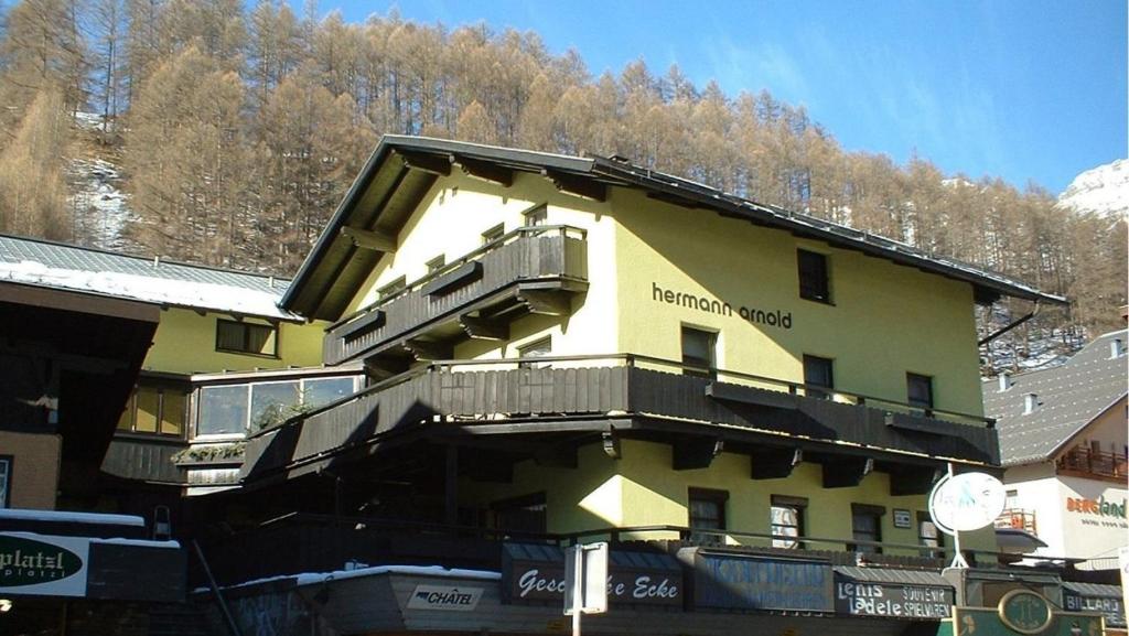 a yellow building with a balcony on the side of it at Gästepension Hermann Arnold in Sölden