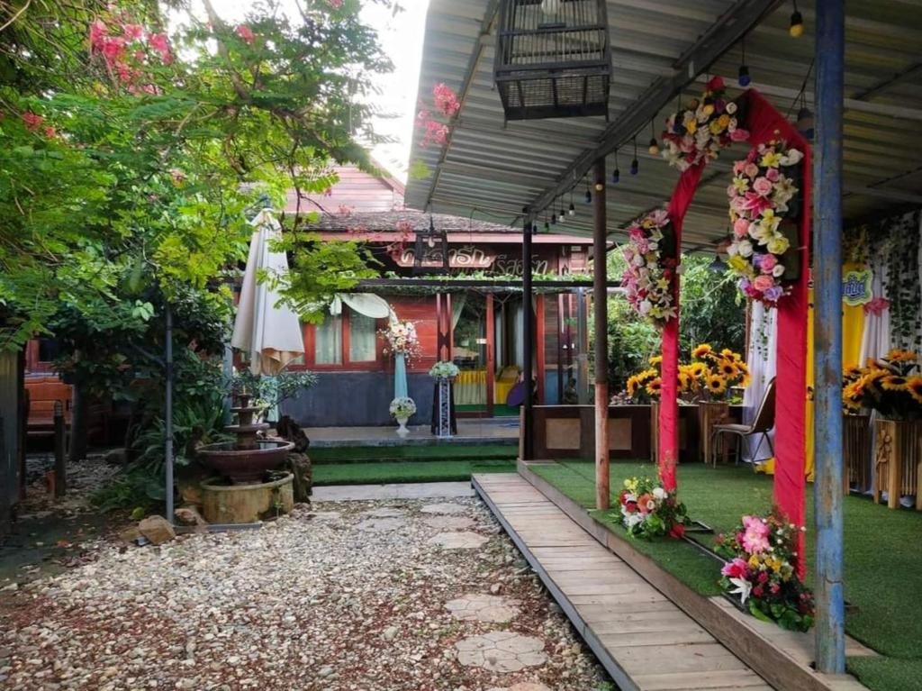 una casa con un jardín con flores. en ต้นพร้าวรีสอร์ท Ton prao Resort, en Ban Pa Tan