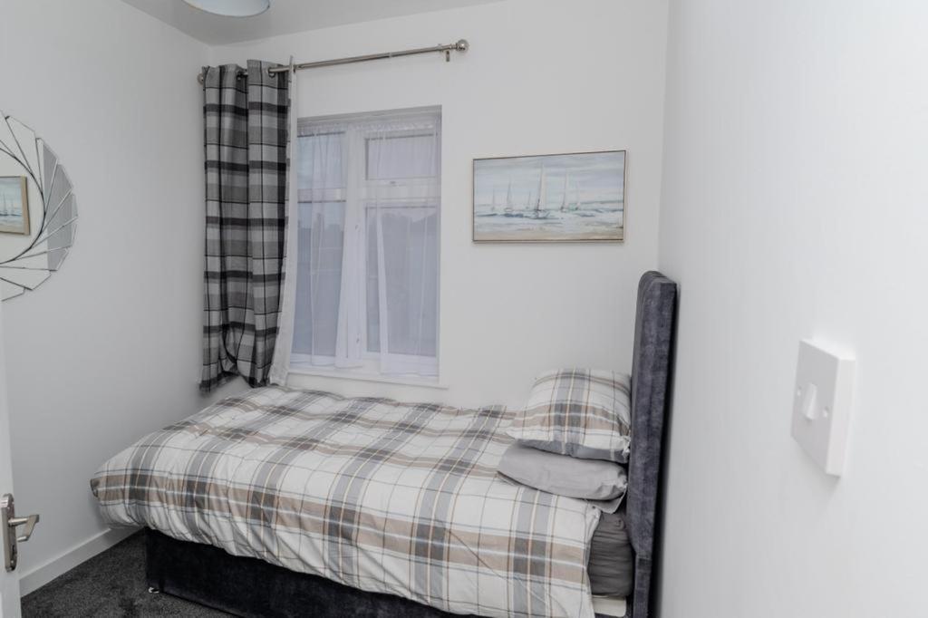 a bedroom with a bed and a window at Exclusive single room in Ilford