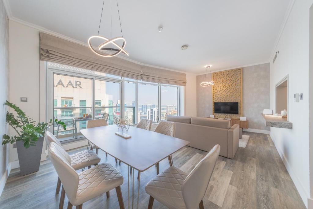 een eetkamer en een woonkamer met een tafel en stoelen bij Boutique Living - Burj Views - Renovated in Dubai