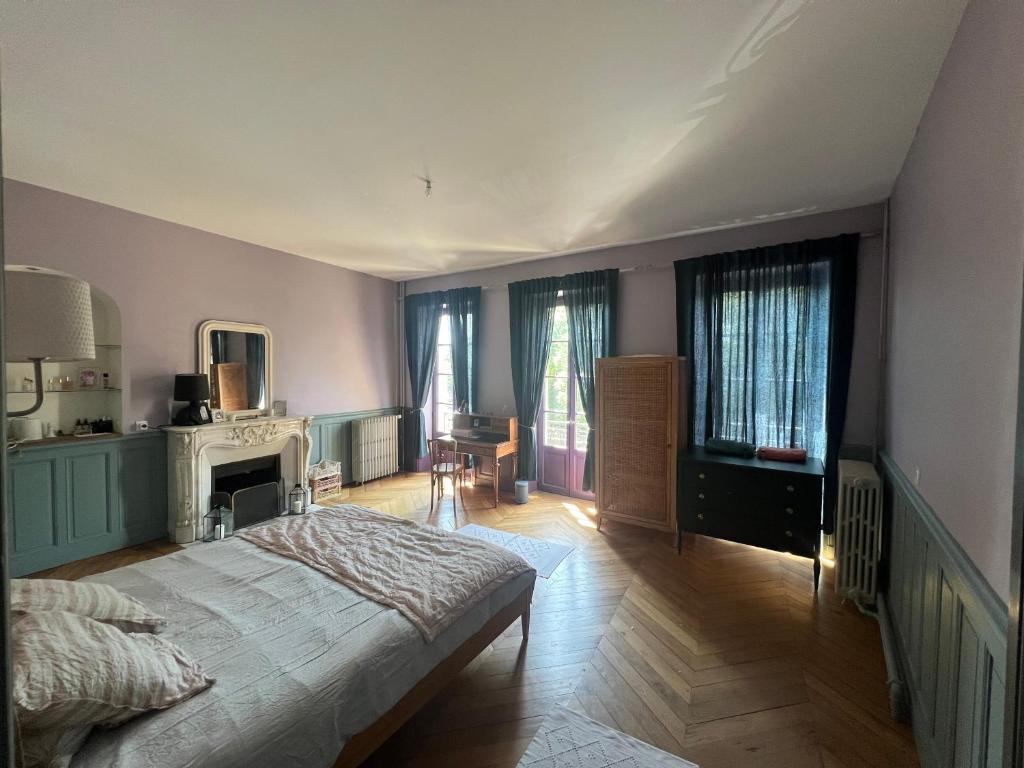 ein Schlafzimmer mit einem Bett und ein Zimmer mit einem Kamin in der Unterkunft Les chambres de Juliette in Moulins