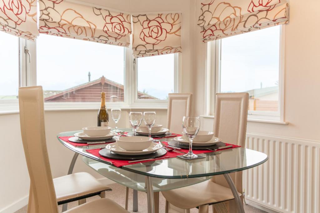 a dining room with a glass table and chairs at 46 Meadow View in Woolacombe