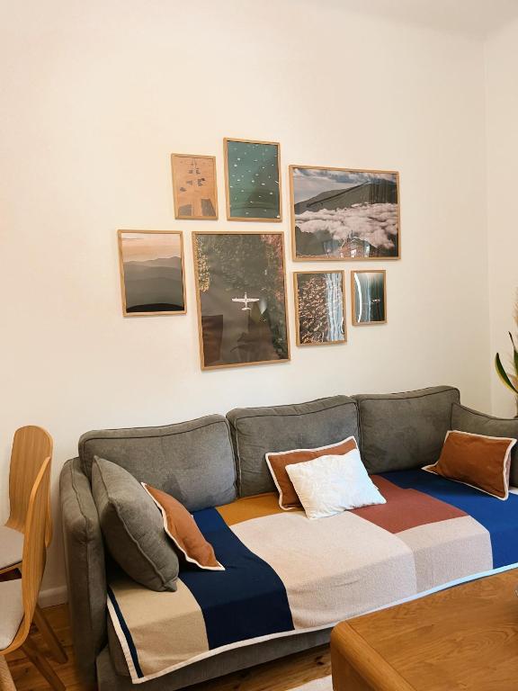 a couch in a living room with pictures on the wall at Nomas SKG Stylish Apartment in Thessaloniki