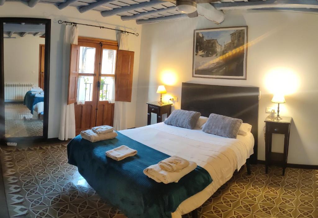 a bedroom with a large bed with towels on it at La Herrera lll in San Esteban de la Sierra