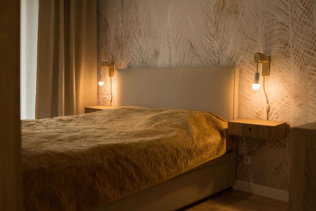 a bedroom with a bed with two night stands and a lamp at Apartament Sand & Sun in Sianozety