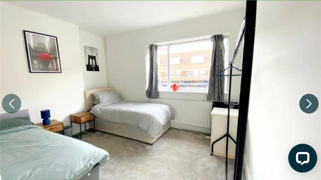 a bedroom with two beds and a window at 4 bedroom property which sleeps 8 very close to the Harry Potter studio and Watford junction in Leavesden Green