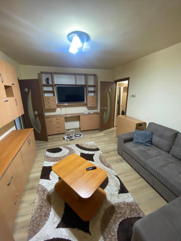 ein Wohnzimmer mit einem Sofa und einem Tisch in der Unterkunft Apartament regim hotelier Deva in Deva