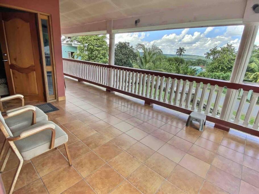 Habitación con balcón y ventana grande. en Mountain View Family Home In Town With King Suite en San Ignacio
