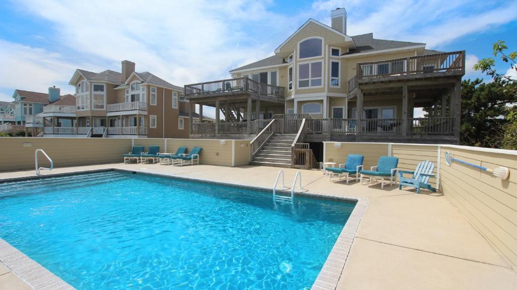 a large house with a swimming pool in front of a house at PI76, Life of Reilly- Oceanfront, Ocean Views, Private Pool, Private Beach Access, Foosball in Corolla