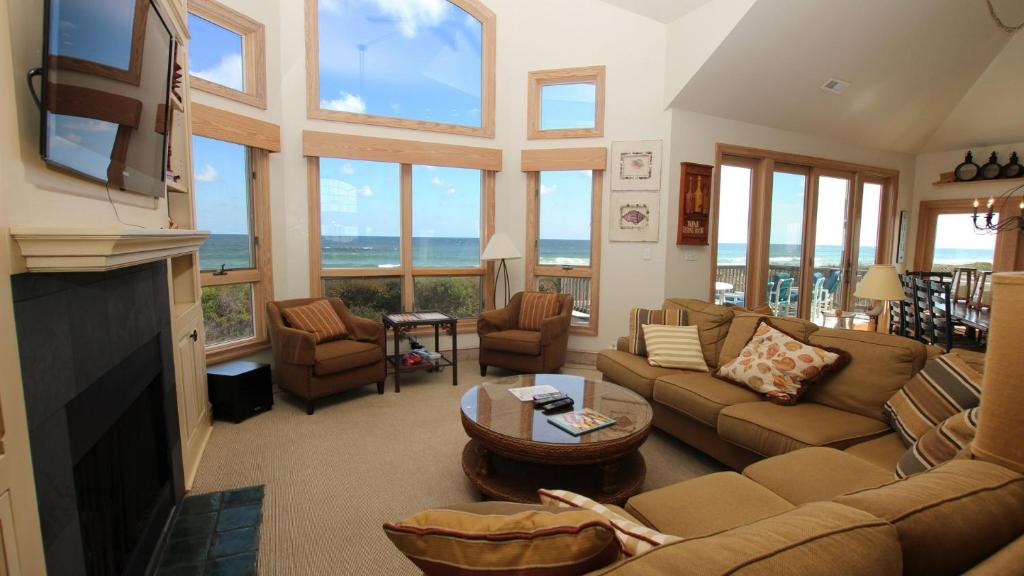 a living room with a couch and a fireplace at PI76, Life of Reilly- Oceanfront, Ocean Views, Private Pool, Private Beach Access, Foosball in Corolla