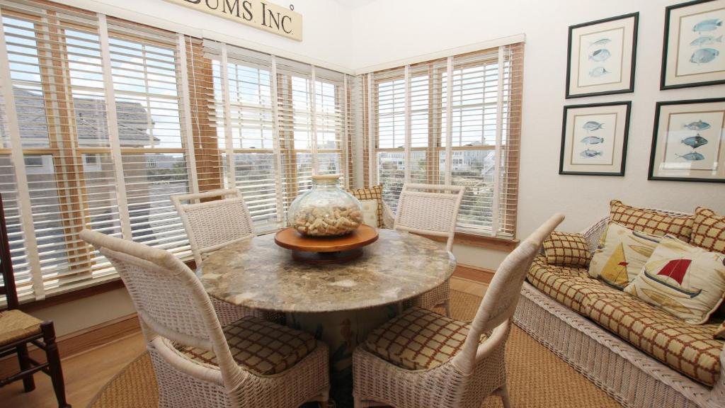a living room with a table and chairs and a couch at PI76, Life of Reilly- Oceanfront, Ocean Views, Private Pool, Private Beach Access, Foosball in Corolla