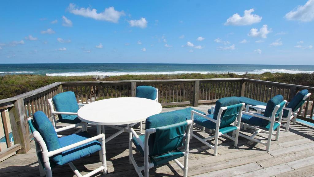 a table and chairs on a deck with the beach at PI76, Life of Reilly- Oceanfront, Ocean Views, Private Pool, Private Beach Access, Foosball in Corolla