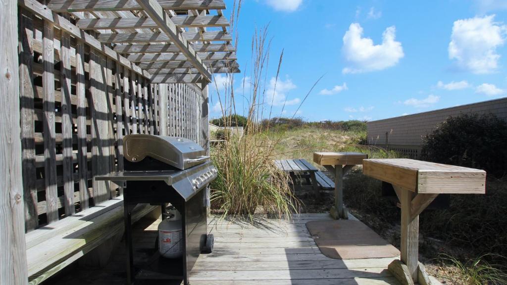 a barbecue grill and a bench on a patio at PI76, Life of Reilly- Oceanfront, Ocean Views, Private Pool, Private Beach Access, Foosball in Corolla