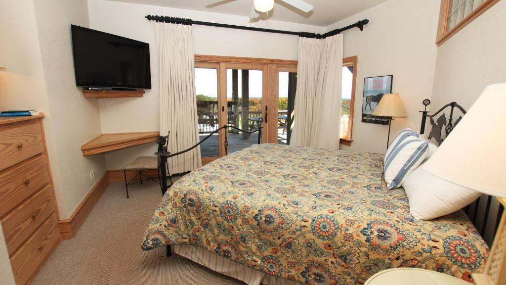 a bedroom with a bed and a flat screen tv at PI76, Life of Reilly- Oceanfront, Ocean Views, Private Pool, Private Beach Access, Foosball in Corolla