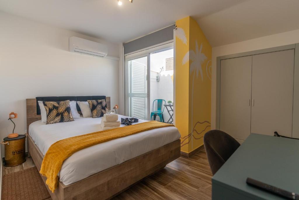 a bedroom with a large bed and a balcony at Leevin Guesthouse in Faro