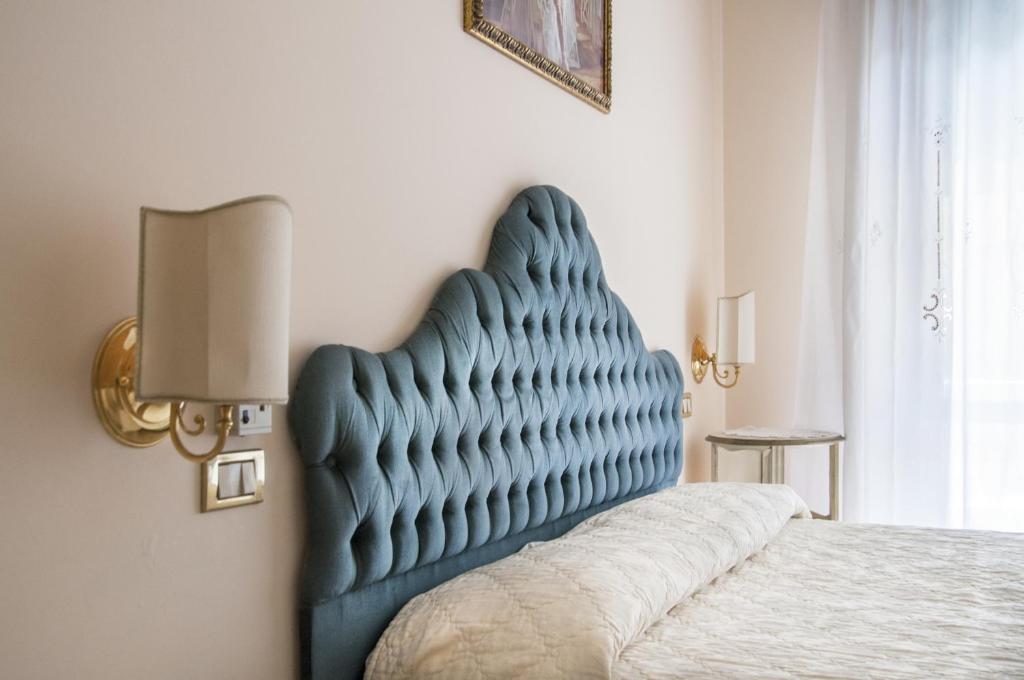 a blue tufted headboard of a bed in a bedroom at Hotel Villa Serena in Marghera