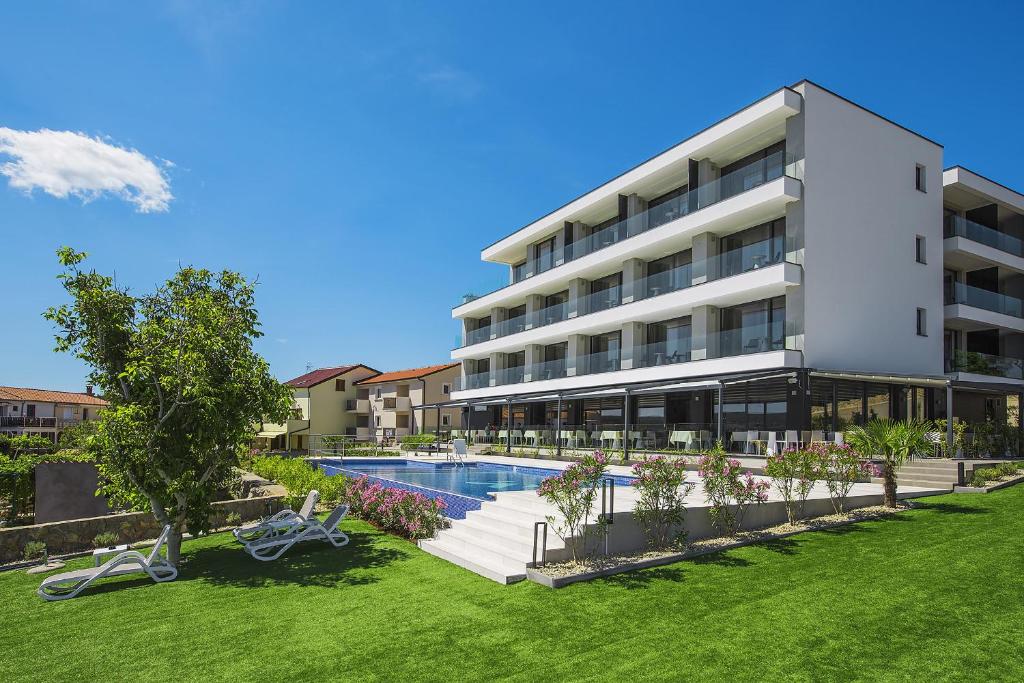 an image of an apartment building with a swimming pool at Hotel Villa Margaret in Malinska