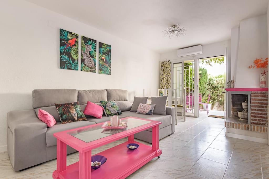 sala de estar con sofá y mesa rosa en Bungalow con encanto, en San Juan de Alicante
