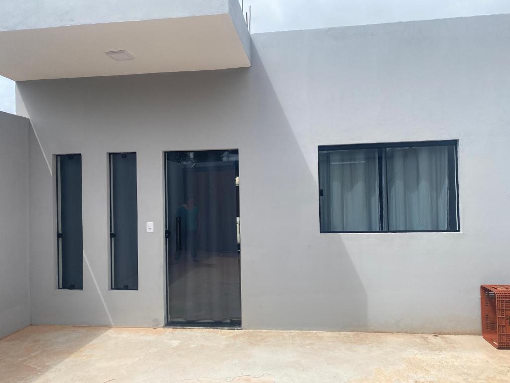 two windows on the side of a white wall at Casa Jardim Primavera in Cunha