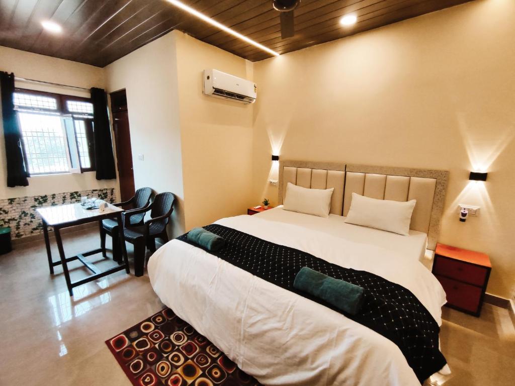 Un dormitorio con una cama grande y una mesa con sillas. en Sunrise Homestay en Agra