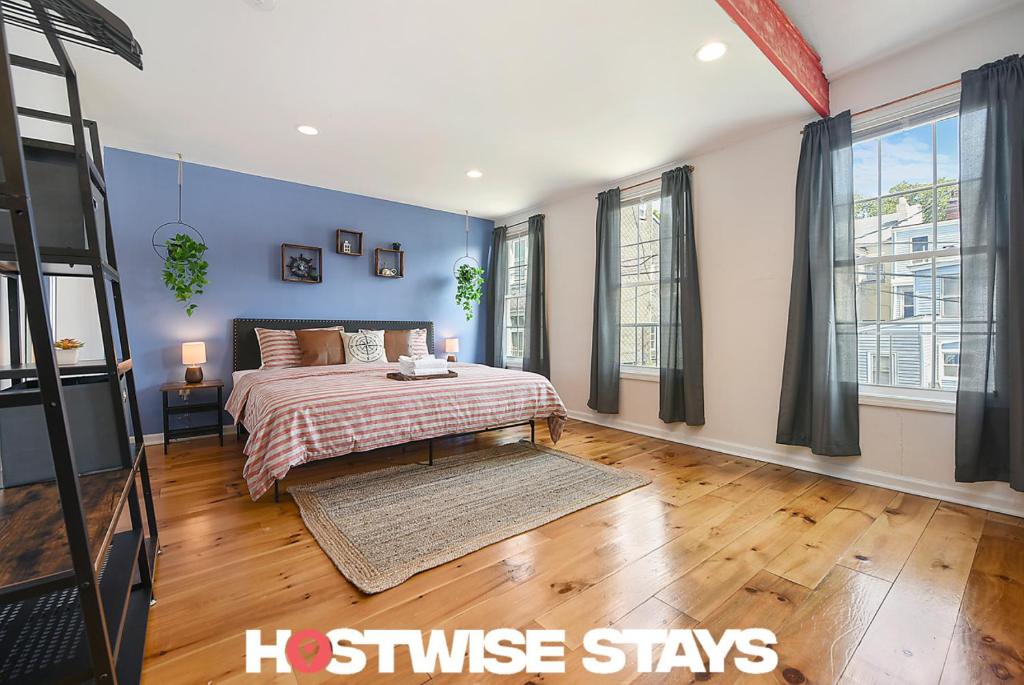 Schlafzimmer mit einem Kingsize-Bett und blauen Wänden in der Unterkunft HostWise Stays - The "Row" House - Beautiful Space, Two King Beds in Pittsburgh