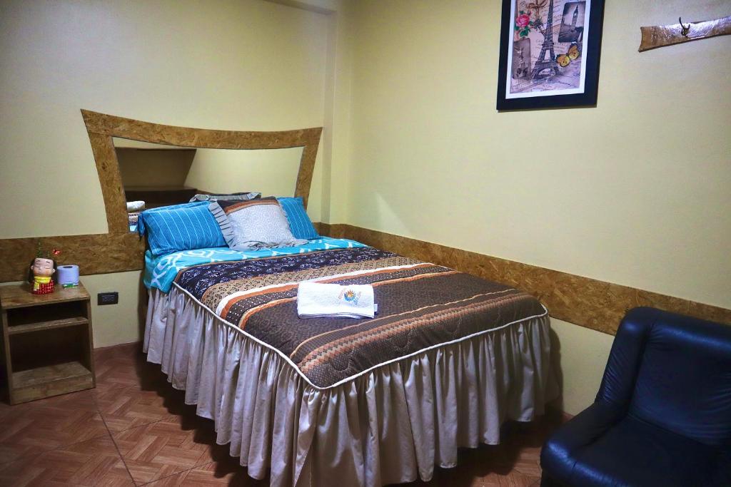 1 dormitorio con 1 cama y 1 silla en HOSTAL SOL & LUNA, en Huánuco