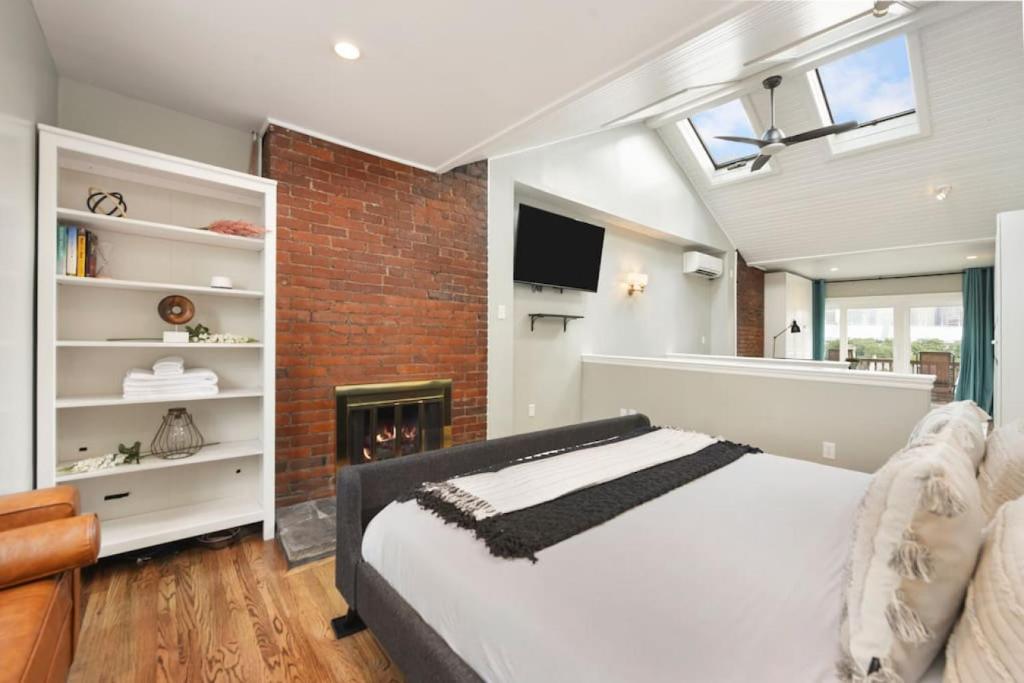 ピッツバーグにあるHostWise Stays - Great Balcony Views, Patio, Minutes to Stadiumsのベッドとレンガの壁がある寝室