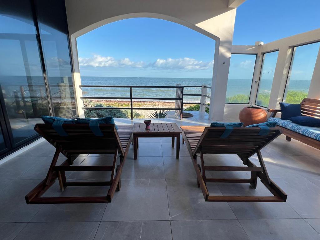 uma sala de estar com mesa e cadeiras e o oceano em Playanet em Chelem