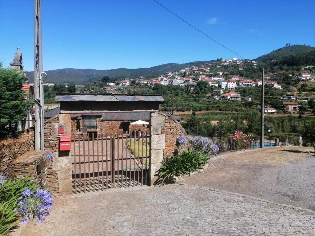 a gate on a hill with a town in the background at Casa de Campo "Quinta do Cadafaz" in Alvarenga