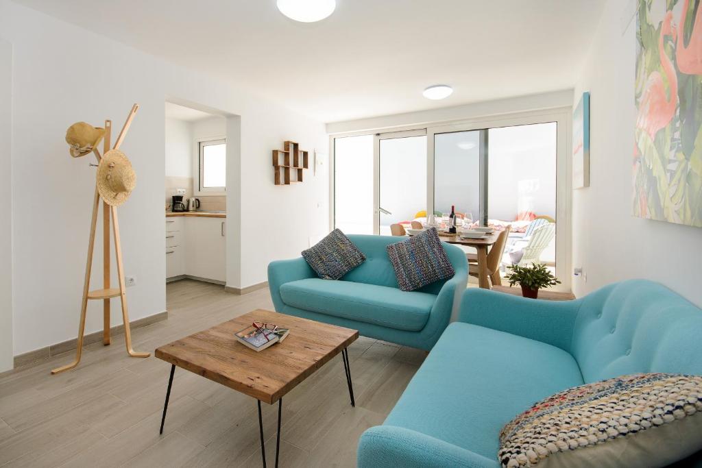 un salon avec deux canapés bleus et une table dans l'établissement White Volcano pool, gym and activities in Sport Center Fariones included, à Puerto del Carmen