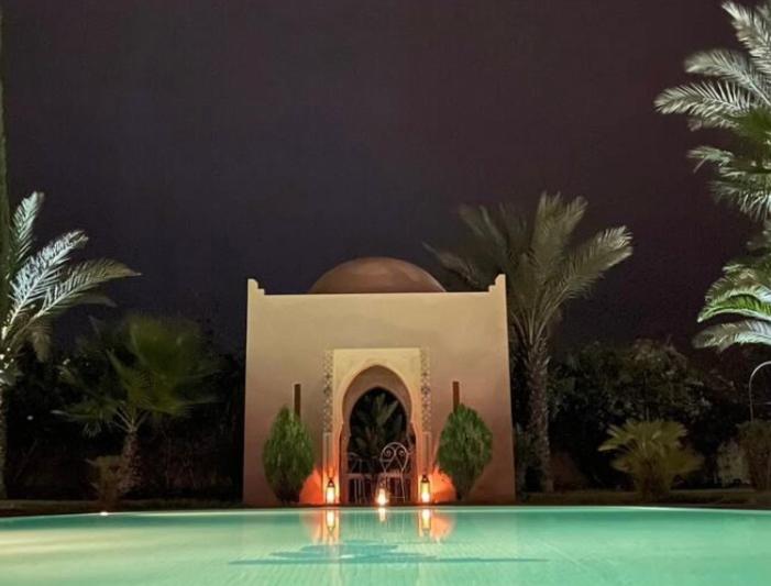 een gebouw met een zwembad ervoor bij Dar Zeitoun in Marrakesh