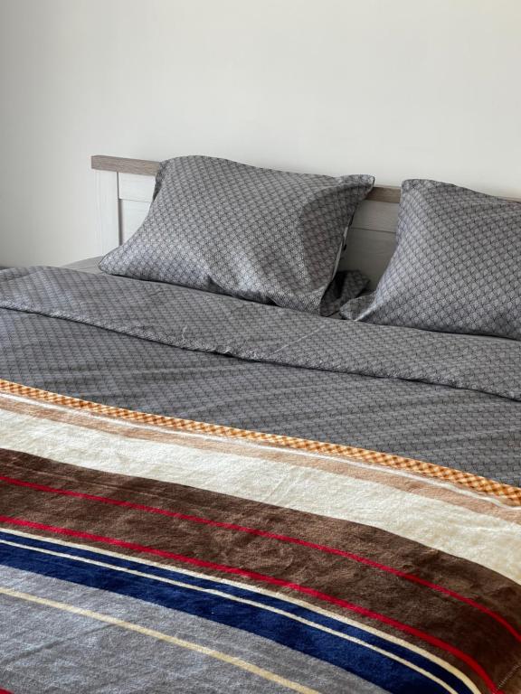 a bed with a comforter on top of it at Y&Y apartments in Bratislava