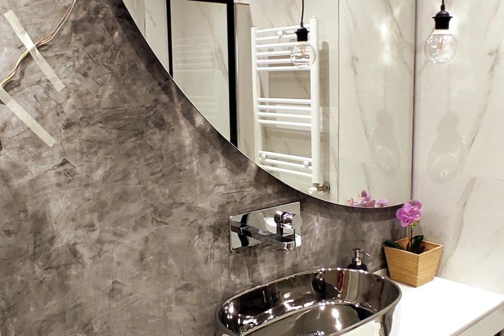ein Bad mit einem Waschbecken und einem Spiegel in der Unterkunft cozy apartment 2 in Thessaloniki