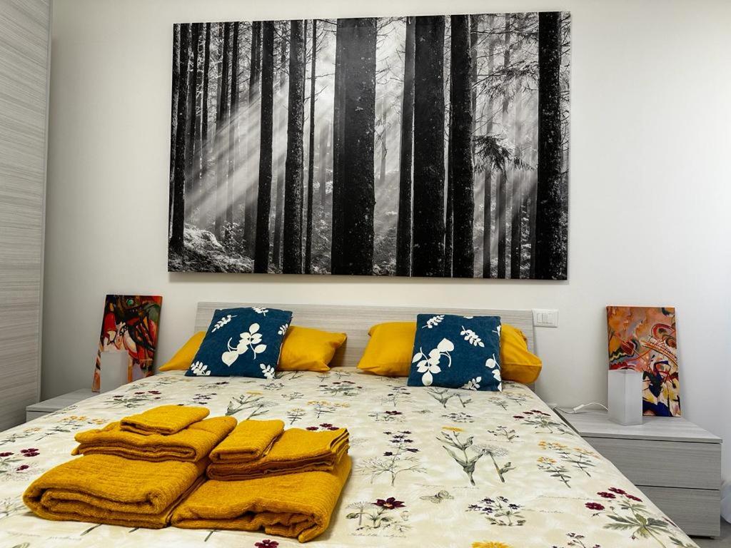 1 dormitorio con 1 cama con una pintura en la pared en Il Nido di Domi, en LʼAquila