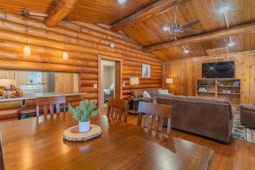 a dining room and living room with a wooden ceiling at The Alaskan Dream Lodge in Fairbanks